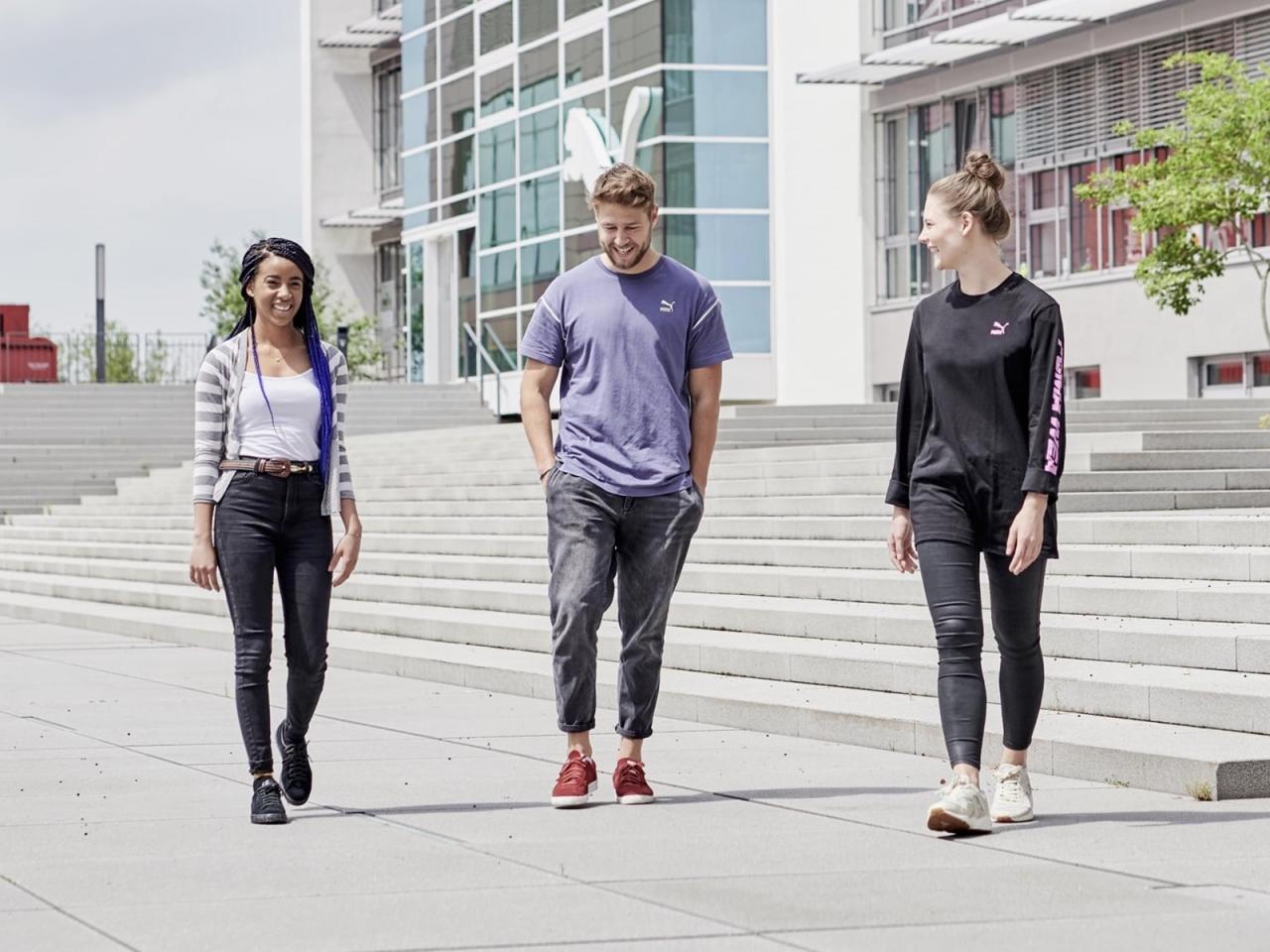 three employees outside of PUMA building